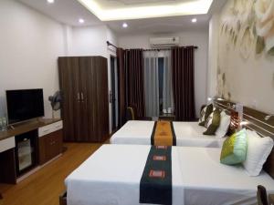 una camera d'albergo con due letti e una televisione di Friendly Home Hotel a Ninh Binh