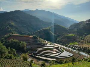 an aerial view of a mountain valley with a river at Indigenous homestay - Trek & Local Life in Mù Cang Chải