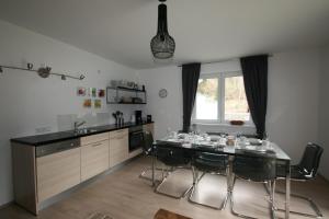 a kitchen with a table and chairs and a kitchen with a counter at Apartment Daum - Deine Ferienwohnung in Mühlbach am Hochkönig in Mühlbach am Hochkönig
