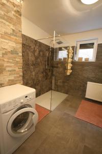 a bathroom with a washing machine and a shower at Apartment Daum - Deine Ferienwohnung in Mühlbach am Hochkönig in Mühlbach am Hochkönig +46 photos