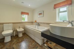 a bathroom with a tub and a toilet and a sink at Beadale Cottage in Ampleforth +20 photos