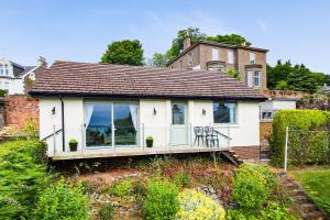 uma casa branca com um alpendre num quintal em FerryView em Broughty Ferry