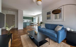 a living room with a blue couch and a table at Apartament LUMOS by Pedro Polanica in Polanica-Zdrój