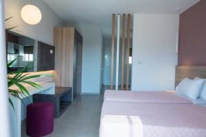 een slaapkamer met een bed en een potplant bij Gelli Apartments in Kos-stad