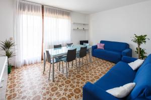 Una sala de estar con un sofá azul y una mesa. en Appartamento Calmo 3DX, en Lido de Venecia