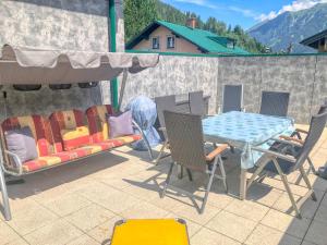 een tafel en stoelen op een patio met een tafel en stoelen bij Apartment Birke 3 - by Alpen Apartments in Bad Gastein