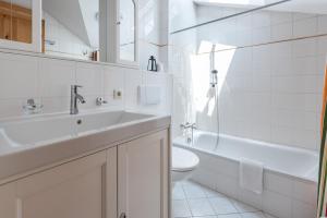 a white bathroom with a sink and a toilet at Apartment Südblick Kitzbühel by Alpine Host Helpers in Kitzbühel