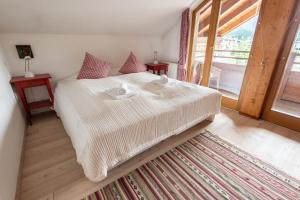 a bedroom with a bed and a large window at Apartment Südblick Kitzbühel by Alpine Host Helpers in Kitzbühel