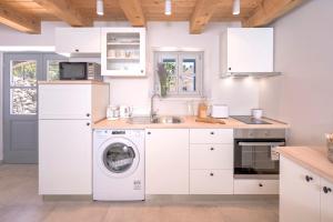 a white kitchen with a washing machine and a sink at Villa Zanino in Veliko Grablje