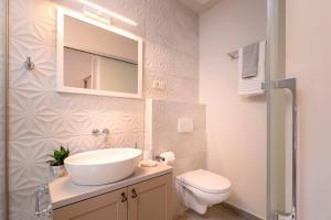 a bathroom with a sink and a toilet and a mirror at Villa Zanino in Veliko Grablje