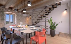 a dining room with a table and chairs and stairs at Villa Zanino in Veliko Grablje