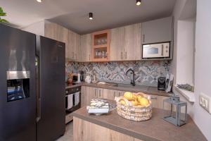 a kitchen with a black refrigerator and a basket of fruit at Villa Zanino in Veliko Grablje