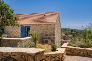 a stone house with a blue door and a stone wall at Villa Zanino in Veliko Grablje