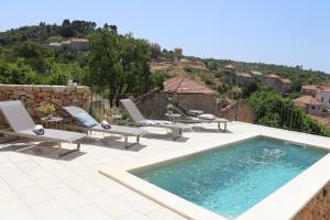 a pool with chaise lounge chairs and a swimming pool at Villa Zanino in Veliko Grablje