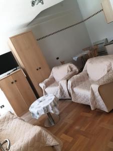 Zimmer mit 2 Betten, einem Stuhl und einem TV in der Unterkunft Šmartno Apartmaji Sobe Joško in Šmartno