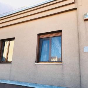 kot siedzący w oknie budynku w obiekcie Kistímár Apartman w mieście Pecz