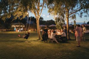 eine Gruppe von Menschen, die in einem Park am Tisch sitzen in der Unterkunft Son Granot Hotel Rural & Restaurant in Es Castell