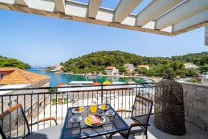 a table on a balcony with a view of the water at Corallium Blue in Pomena