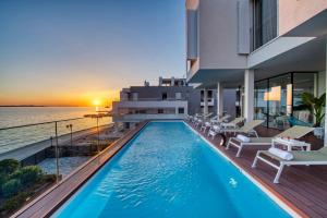 a swimming pool on the balcony of a building with the ocean at Dedaj Resort - Villa Tina in Zadar