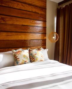 a bedroom with a wooden headboard and a bed with pillows at Ahana Resort El Nido in El Nido