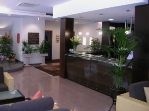 a lobby with potted plants in a building at Hotel Miramare in Caorle