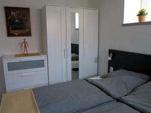 sypialnia z łóżkiem, komodą i lustrem w obiekcie művészház apARTman w Balatonfüred
