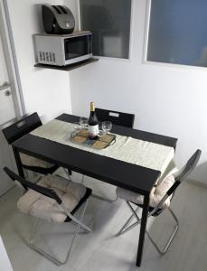 czarny stół z 2 krzesłami i butelką wina w obiekcie művészház apARTman w Balatonfüred
