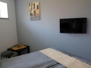 a bedroom with a bed and a flat screen tv at művészház apARTman in Balatonfüred