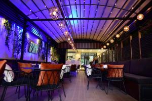 un restaurant avec un plafond violet et des tables et des chaises dans l'établissement Hotel Comfort, à Tirana