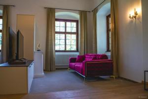 a living room with a purple couch and a window at Innviertler Versailles in Aurolzmünster