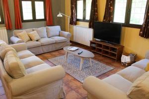 a living room with couches and a flat screen tv at Casa El Tío Carrascón alojamiento rural in Cerveruela