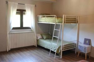 a bedroom with two bunk beds and a window at Casa El Tío Carrascón alojamiento rural in Cerveruela
