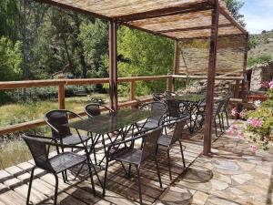 un grupo de mesas y sillas en una cubierta en Casa El Tío Carrascón alojamiento rural, en Cerveruela