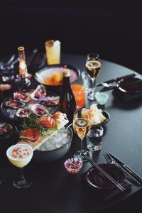 a table topped with plates of food and glasses of wine at Clarion Hotel Sea U in Helsingborg