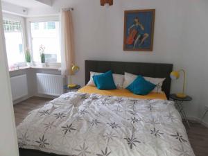 a bedroom with a large bed with blue pillows at Villa Grassenberg in Marburg an der Lahn