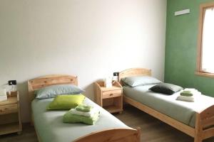 - 2 lits dans une chambre aux murs verts dans l'établissement Appartamento a due passi da Bormio, à Valdisotto