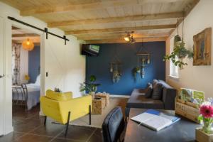 ein Wohnzimmer mit einem gelben Sessel und einem Sofa in der Unterkunft De Slaaperij in Wilbertoord