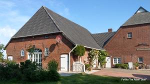 a large red brick building with a black roof at Im Alten Stall in Loxstedt