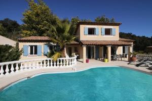 eine Villa mit einem Pool vor einem Haus in der Unterkunft Villa -Vue panoramique splendide -Piscine privée in Auribeau-sur-Siagne