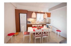 Una cocina y un comedor con mesa y sillas. en Seaside Family House, en Nikiana