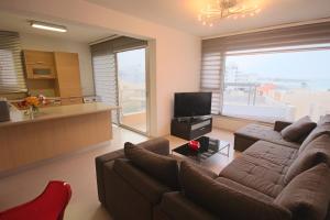 a living room with two couches and a kitchen at Fig Tree Bay Apartments in Protaras