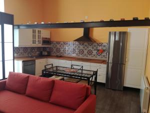 a living room with a red couch in a kitchen at Centro Histórico con parking Cádiz in Cádiz