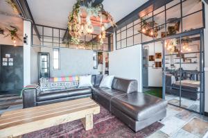 Una sala de estar con un sofá de cuero y una mesa. en De Vuurtoren, en Yzerfontein