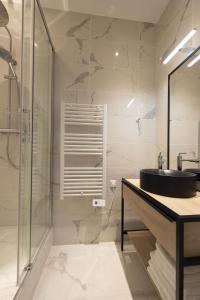 een badkamer met een wastafel en een glazen douche bij Time Line in Parijs