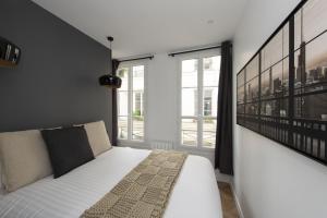 una camera da letto con un letto bianco e una finestra di Time Line a Parigi
