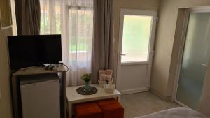 a room with a television and a table and a window at Casa Lira Orșova in Orşova +26 photos