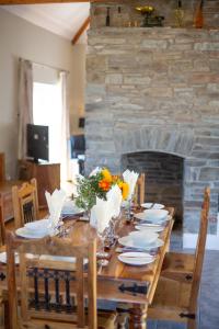 uma mesa de madeira com flores e uma lareira em The Coal House em Kidwelly