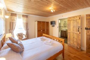 a bedroom with a large bed with a wooden ceiling at The Coal House in Kidwelly