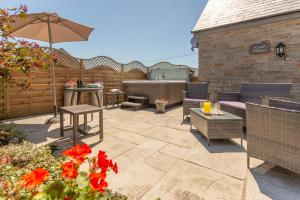 a patio with a table and chairs and an umbrella at The Coal House in Kidwelly