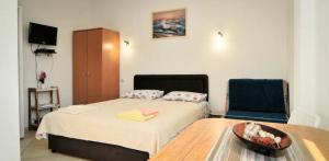 um quarto com uma cama, uma mesa e uma cadeira em Busola Apartments em Tivat